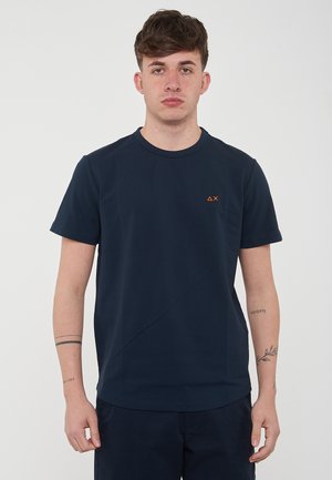 T-shirt in cotone blu navy a maniche corte con scollo rotondo e dettaglio del logo arancione sul lato sinistro del petto. Texture liscia, vestibilità casual.