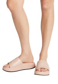 Růžové nazouvací sandály s chunky platformou a otevřenou špičkou. Vyznačují se embosovaným logem na širokém pásku a hladkým, lesklým povrchem.