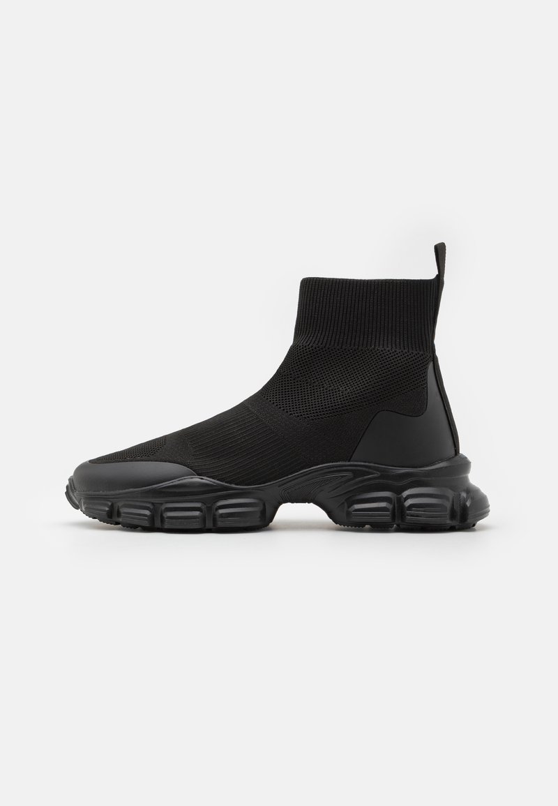 Black athletic sock sneakers with a ribbed knitted upper, flexible sole, and cushioned rubber outsole featuring prominent tread patterns.