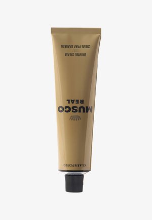 Tube mit Musgo Real Rasiercreme mit schwarzem Deckel auf weißem Hintergrund, beige Verpackung mit schwarzem Text.