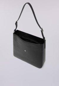 Czarna prostokątna torba na ramię z regulowanym paskiem, otwarta od góry z wewnętrzną kieszenią na zamek oraz małym okrągłym metalowym detalem z przodu.