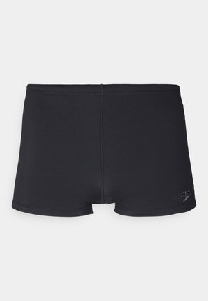 Shorts de bain noirs en matériau extensible, avec une texture lisse, une coupe courte et un détail de logo subtil sur le côté.