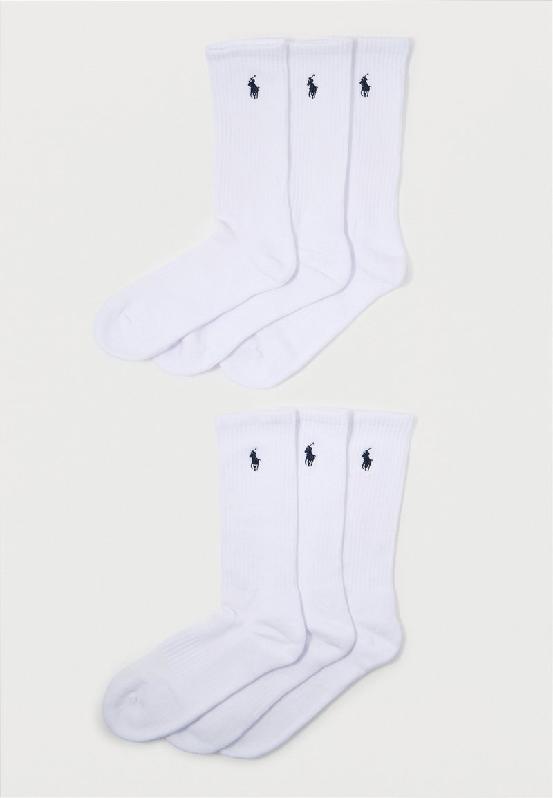Witte crew-sokken met ribbelstructuur; voorzien van een klein zwart polo-logo op elke sok. Verpakking bevat vier paar met een consistent ontwerp.
