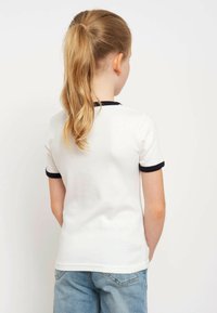 White T-shirt with navy blue trim on sleeves and collar, made of cotton; depicted from the back, showing a simple and classic design.