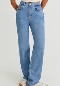 Jean taille haute bleu clair avec une coupe droite, en denim. Comprend des poches avant et une fermeture à un seul bouton.