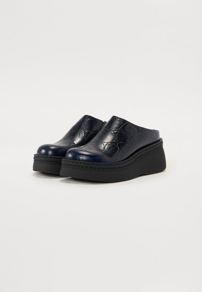 Pantofi slip-on din piele bleumarin cu finisaj texturat, talpă platformă ridicată și toc din cauciuc negru în contrast. Design neted și structurat.