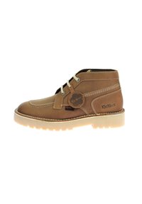 Botín de cuero marrón con costuras blancas, punta redonda, diseño de cordones, suela de goma y etiqueta con el logo de Kickers en el lado.