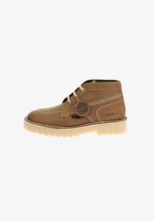 Bruine leren enkelboot met witte stiksels, ronde neus, vetersluiting, rubberen zool en Kickers-logo tag aan de zijkant.