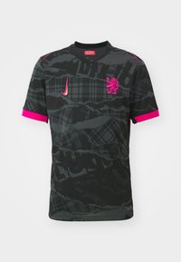 Maglia sportiva nera con motivo testurizzato, dettagli rosa sul colletto e sulle maniche, e logo Nike. Presenta un emblema di leone sul petto.