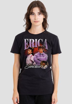 Young woman wearing a black t-shirt featuring three images of Erica Sinclair with purple text and a red background.