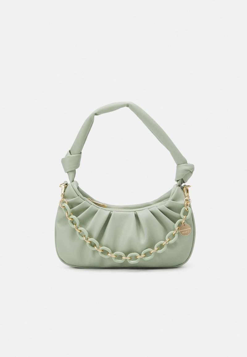 Sac à main vert doux froncé avec bandoulière nouée et détail de chaîne dorée, avec un petit porte-bonheur rond et une fermeture éclair.