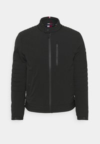 Černá prošívaná bunda s stojatým límcem, celopropínacím zipem vpředu, kapsou na zip na hrudi, manžetami na druky a vycpávkami na rukávech a spodním lemu.