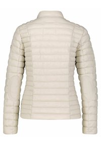 Chaqueta acolchada color beige claro con diseño ajustado, textura acolchada y parches en los codos. Presenta un cuello alto y tela lisa.