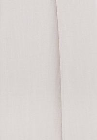 Ljusbeige tyg med en vertikal söm som löper ner längs högra sidan, vilket visar en subtil struktur och fina sömnadsdetaljer.