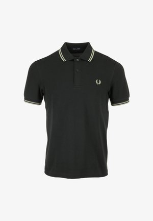 Polo nero in cotone, con pattina a due bottoni, colletto con righe crema e un piccolo emblema ricamato sul petto.