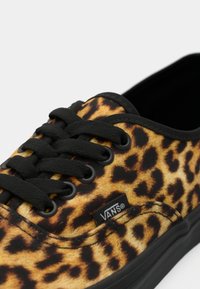 Leopardprint canvas sneaker met zwarte veters en accenten. Voorzien van een rubberen zool en een klein zwart Vans logo label aan de zijkant.