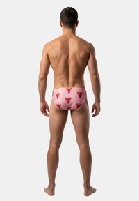 Kąpielówki w różowym materiale z powtarzającym się czerwonym nadrukiem homarów. Elastyczny pas, dopasowany krój i gładka faktura. Pokazano widok od tyłu.