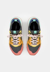 Colorful sneakers featuring a mesh upper in black with yellow, pink, and blue accents. Textured laces and a padded collar complete the design.