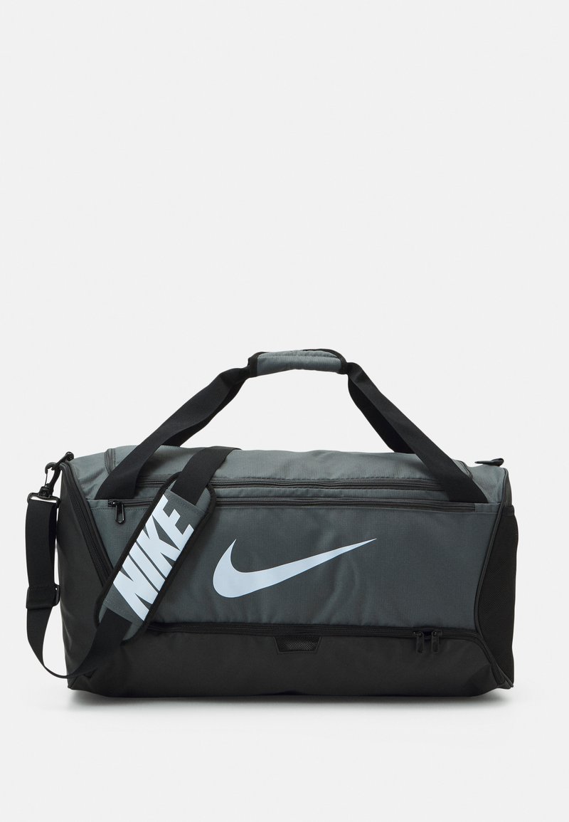 Mala de desporto Nike com um design em cinza escuro e preto, apresentando um grande logo branco, duas alças e uma correia de ombro ajustável.