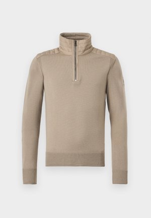 Pull beige à manches longues avec empiècements matelassés sur les épaules, demi-fermeture éclair à l'avant, col montant, et poignets et ourlet côtelés.