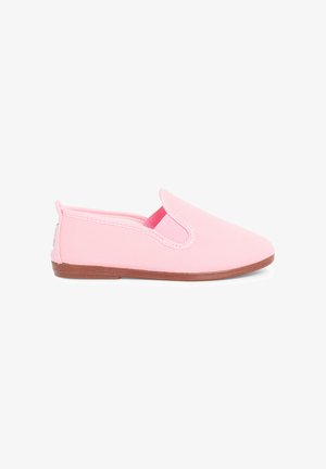 Chaussure en toile rose clair à enfiler, avec semelle plate en caoutchouc marron et élastique sur le côté pour un enfilage facile, montrée sur fond blanc.