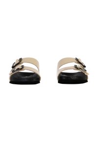 Due sandali slip-on con una toma leggera beige in materiale sintetico, due cinturini regolabili con fibbie nere e una suola in gomma nera.