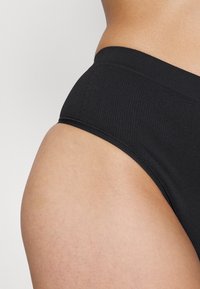 Black ribbed fabric high-waisted brief, featuring a smooth waistband and a close-fitting design, highlighting a simple and classic silhouette.