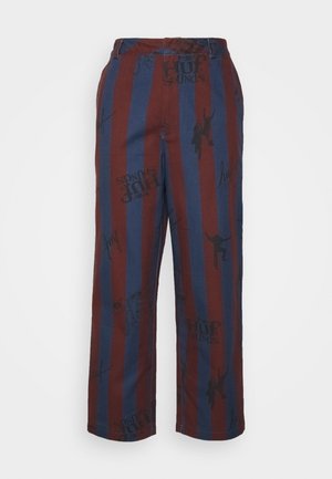 Calças às riscas vermelhas e azuis com um tecido suave, corte descontraído e estampados, incluindo gráficos e texto no material.