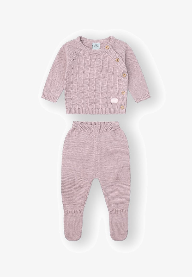 Suéter de punto rosa claro con textura acanalada y tres botones de madera. Los pantalones a juego tienen una cinturilla suave y diseño con pies.