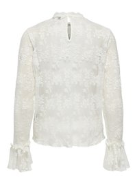 Blouse en dentelle blanche avec motifs floraux, manches longues avec poignets à volants, une petite fermeture à bouton en forme de goutte dans le dos, et une texture légère.