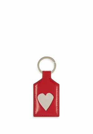 Czerwony skórzany brelok w kształcie metki z wyciętym srebrnym sercem, wyposażony w metalowy pierścień do przypięcia. Gładka tekstura.