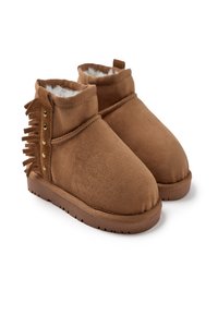 Botas de tobillo de ante marrón con un suave forro de piel, que presentan un detalle de flecos y tachuelas de color dorado en el costado, con una suela de goma texturizada.