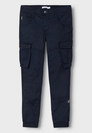 Tumesinine cargo püksid, mis on valmistatud puuvilla segakangast; omavad küljetaskuid, elastseid mansette ja nööpkinnitust. Sile tekstuur.