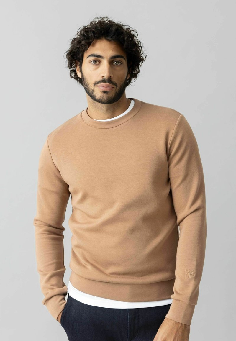 Felpa beige in cotone misto, con scollo tondo e maniche lunghe. Texture sottile, con dettaglio del logo sulla manica.