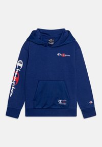 Felpa Champion blu navy con tasca frontale, cappuccio e loghi Champion bianchi e rossi sul petto, sulla manica sinistra e sulla tasca.
