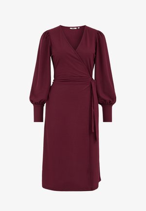 Bordeaux wikkeljurk van zachte stof, met een diepe V-halslijn, pofmouwen en een strikceintuur op de taille. Lengte tot halverwege het kuit.