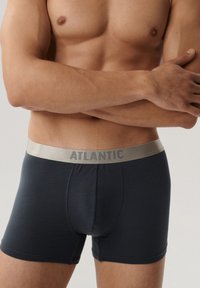 Granatowe bokserki o gładkiej fakturze z jasnoszarym pasem, na którym widnieje mocny napis "ATLANTIC".