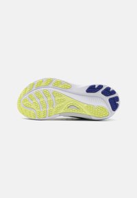 La suola della scarpa presenta una base bianca, sezioni spesse in gomma gialla e blu, pattern di trazione strutturati e un design leggero e flessibile.