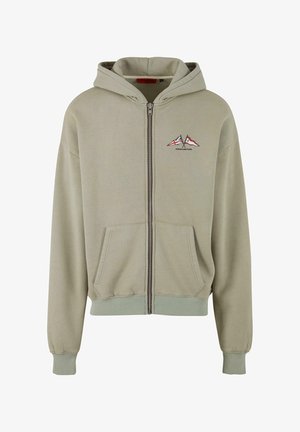 Zipperová mikina vo svetlo olivovo zelenej zmesi bavlny. Má predné vrecko, rebrované manžety a lem a vyšívaný dizajn hory a vlajky na hrudi.