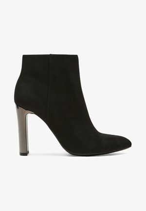 Czarne zamszowe botki sięgające kostki z noskiem w szpic i smukłym obcasem typu stiletto. Obcas posiada metaliczny akcent, podkreślający nowoczesny design.
