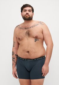 Herren Boxershorts in Dunkelgrau mit einem schwarzen Bund, der das Logo "JACK & JONES" trägt. Der Stoff wirkt glatt und elastisch.