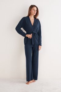 Mörkblå stickad lounge-set med en omlottopp med knytband och vida byxor, båda i mjukt, texturerat tyg.