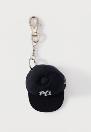 Miniatur-Baseballkappen-Schlüsselanhänger in Marineblau mit weißem Logo, silberner Kette und Metallverschluss auf weißem Hintergrund.