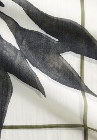 Ein stoff mit Blattmuster zeigt große, dunkelgraue Blätter auf einem weißen Hintergrund, akzentuiert von subtilen grünen Gitterlinien. Glatte Textur.