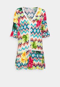 Färgglad blommig tunika med ett zickzackmönster, som har V-hals, korta volangärmar och spetsdetaljer längs framsidan.