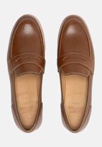 Braune Lederloafers mit strukturierter Oberfläche, im Slip-On-Design, mit gesteppten Nähten und geprägtem Branding auf der Innensohle.