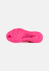 Suola di sneaker rosa brillante con battistrada testurizzato per la presa, caratterizzata da "TRAXION" e ritagli esagonali per la flessibilità. Materiale leggero.