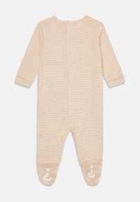 Beige langermet overall med teksturert geometrisk mønster, knappelukking bak, og sklisikre fotdetaljer i mykt materiale.