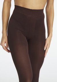 Brown, high-waisted leggings made of soft, stretchy material. Features a smooth texture and reinforced seams, providing a snug fit.