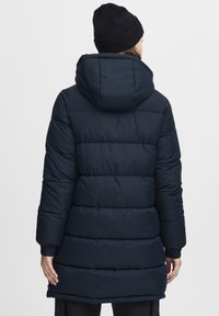Navy blue puffer jacket with a hood, featuring a quilted design, elastic cuffs, and a mid-length cut. Smooth, water-resistant material.
